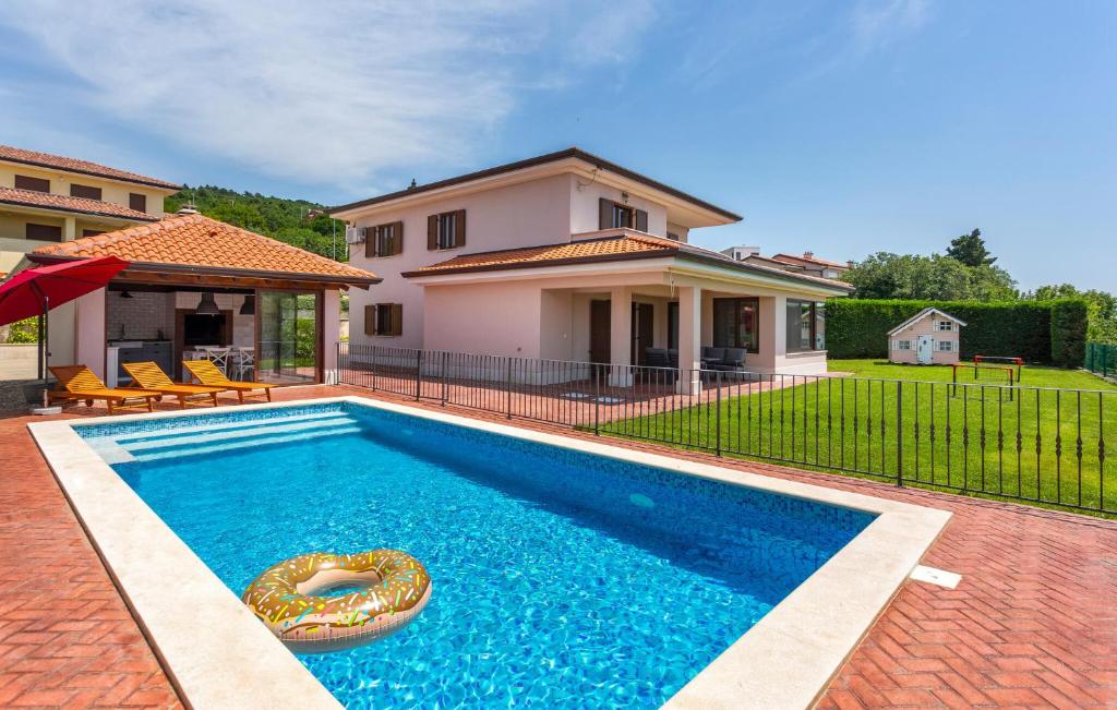 a swimming pool in front of a house at 4 Bedroom Beautiful Home In Kostrena in Kostrena