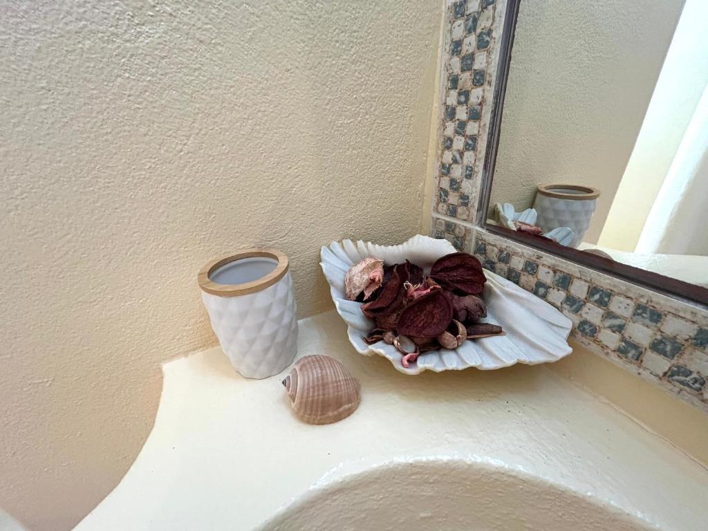 a bathroom counter with a mirror and a vase at Antiparos Diamond in Antiparos Town