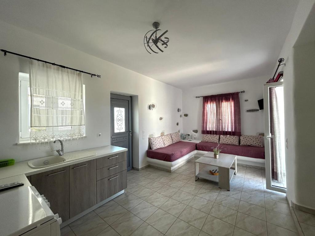 a bathroom with a sink and a couch in a room at Antiparos Diamond in Antiparos Town