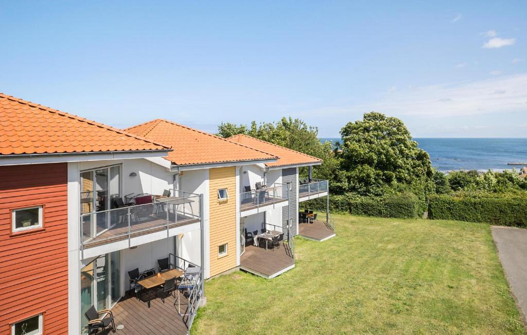 une image d'une maison avec l'océan en arrière-plan dans l'établissement Gudhjem Søpark Lejl 35, à Gudhjem