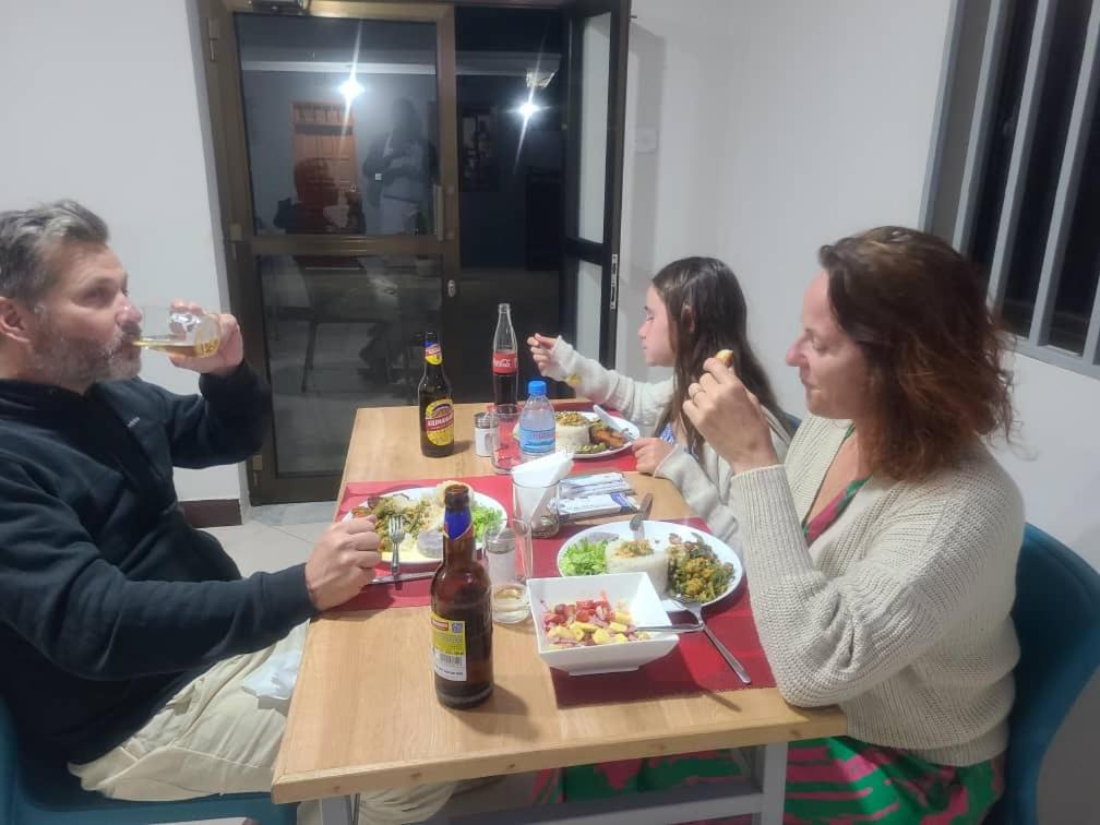 a group of people sitting at a table eating food at Meuly Family Lodge in Arusha