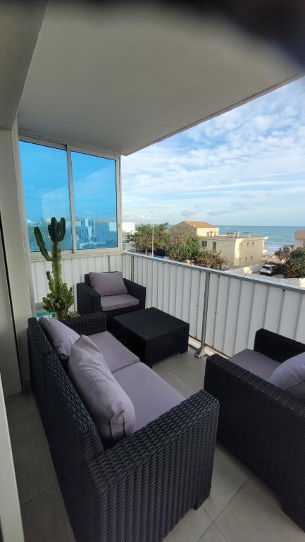 Elle comprend un balcon doté d'un mobilier en osier et offrant une vue sur l'océan. dans l'établissement Superbe appartement vue mer - 2 chambres - parking, à Palavas-les-Flots