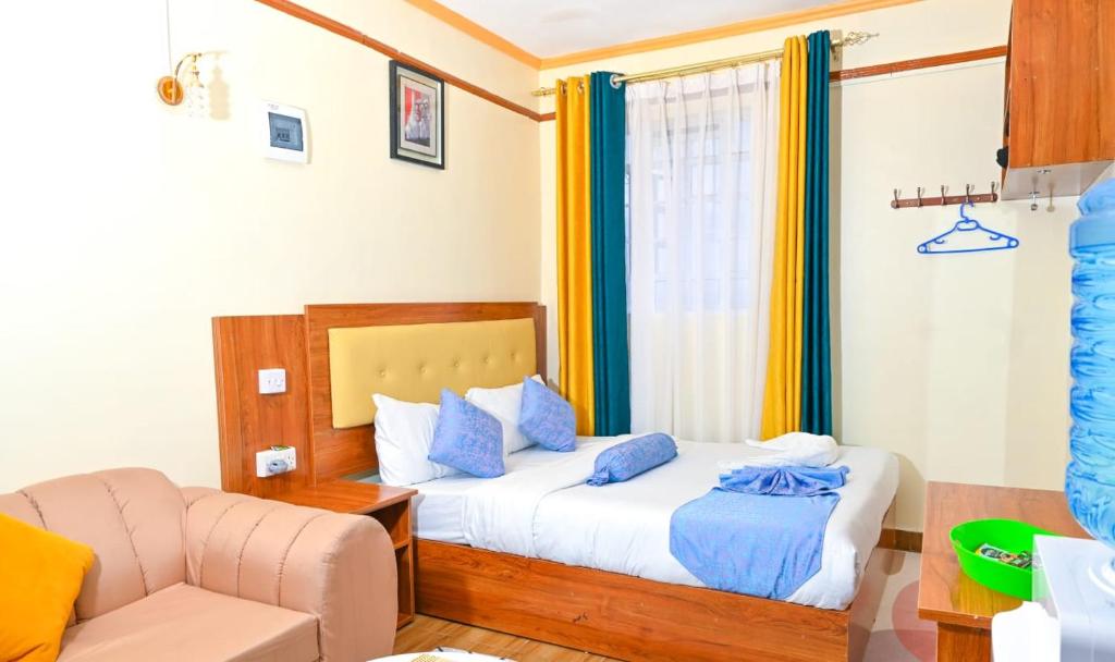 una habitación de hotel con una cama y un sofá en Nellius studios Naivasha CBD, en Naivasha