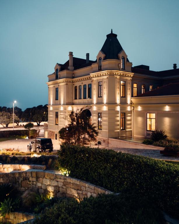 a large white house with a car parked in front of it at Vila Foz Hotel & SPA - member of Design Hotels in Porto