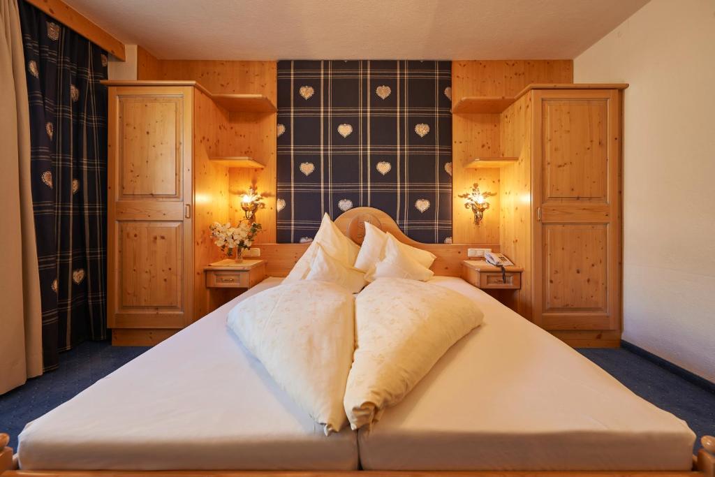 Postel nebo postele na pokoji v ubytování Alpenhotel Laurin