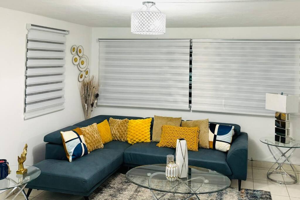 a living room with a blue couch with yellow pillows at Alojamiento completo familiar in Carolina
