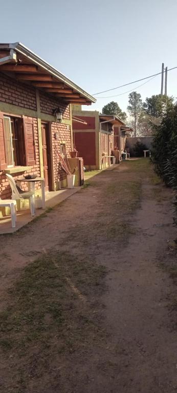 a dirt road in front of a brick building at Apartamentos Agosto in Nueva Galia