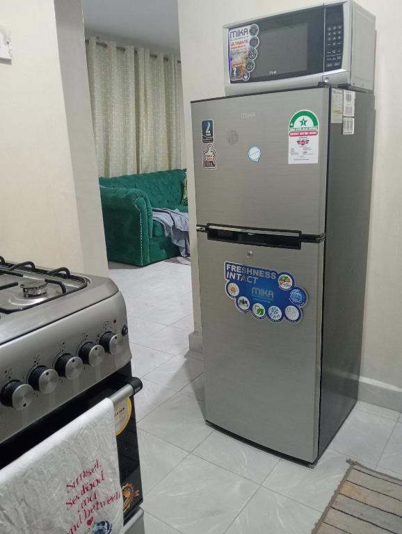 a refrigerator and a stove in a room at Homes by Deuces in Ngong