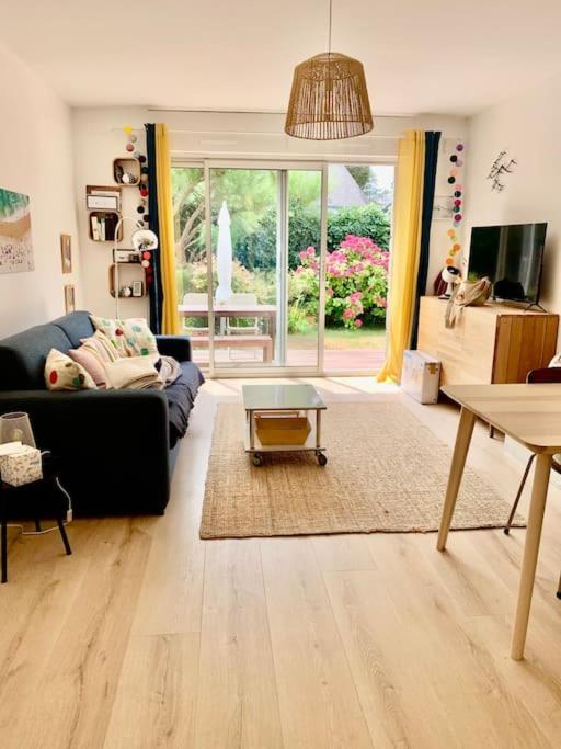 un salon avec un canapé et une table dans l'établissement An Héol-Carnac- Confort- La plage à pieds -Jardin plein sud, à Carnac