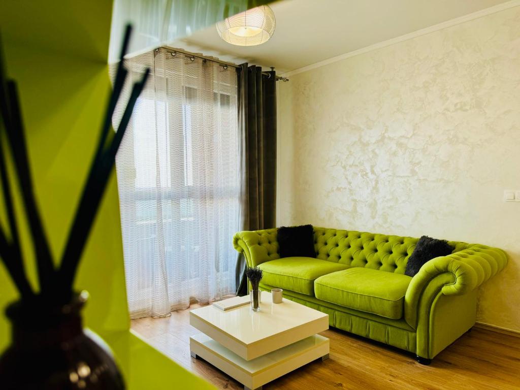 a living room with a green couch and a table at Joy City Stay Forest 84 in Timişoara