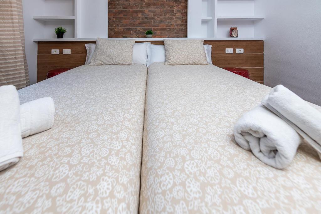 a bedroom with two beds with white sheets and towels at Calas Beach Corralejo in Corralejo