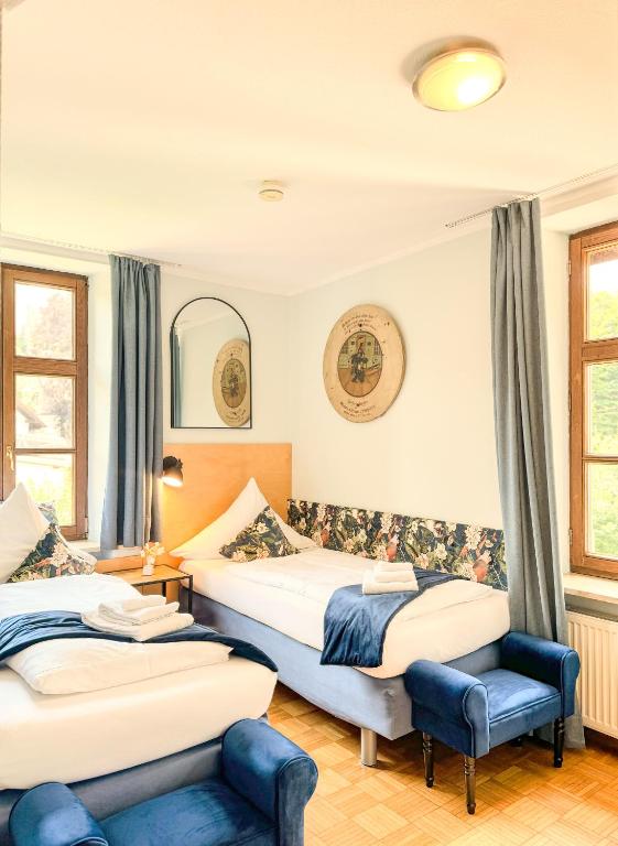 a hotel room with two beds and a chair at Villa Fantasia Budget Boutique Hotel in Füssen