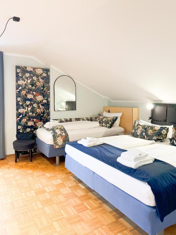 a bedroom with two beds and a mirror at Villa Fantasia Budget Boutique Hotel in Füssen