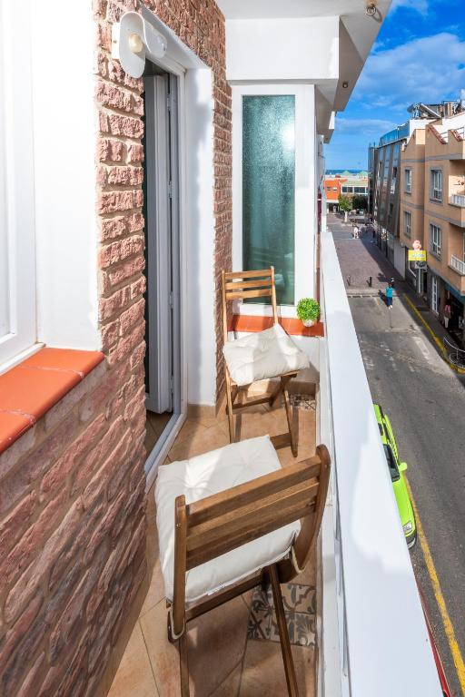 a balcony with two chairs and a table at Calas Beach Corralejo in Corralejo