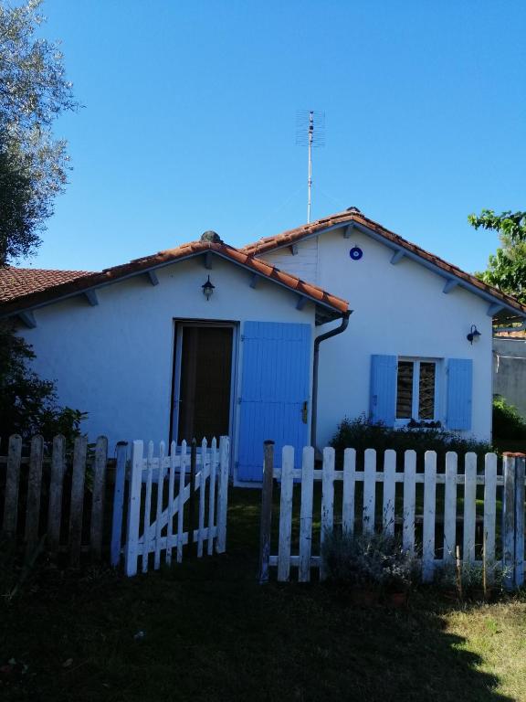 une maison blanche avec une clôture blanche devant elle dans l'établissement Maison de pêcheur, à La Tremblade