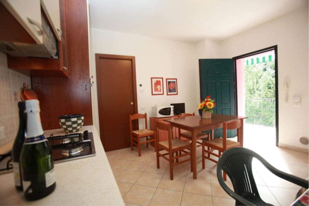 a kitchen and dining room with a table and chairs at Green oasis close to the center in Rosolina Mare