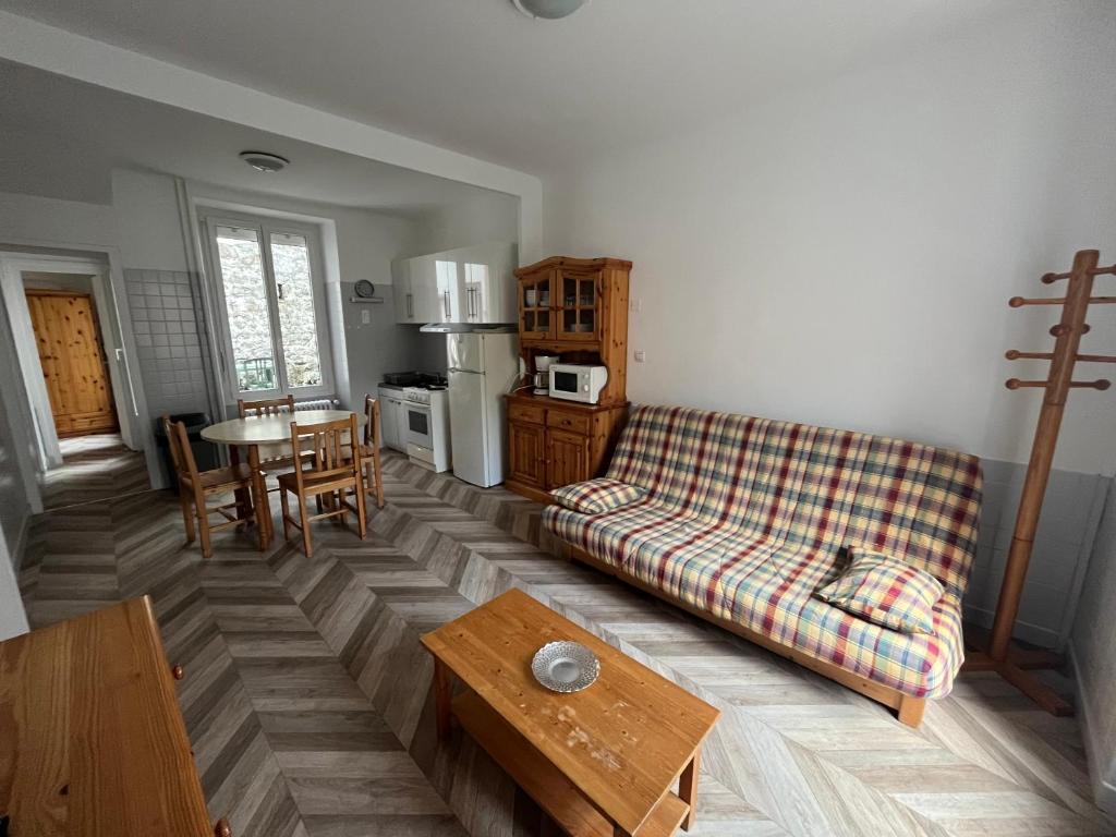 un salon avec un canapé et une table dans l'établissement Altitude Location Montagne Appartement 45, à La Bourboule