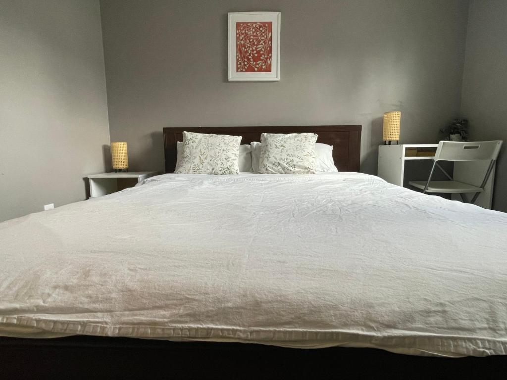 a bedroom with a large white bed with pillows at private room with queen bed in richmond 202 in Richmond
