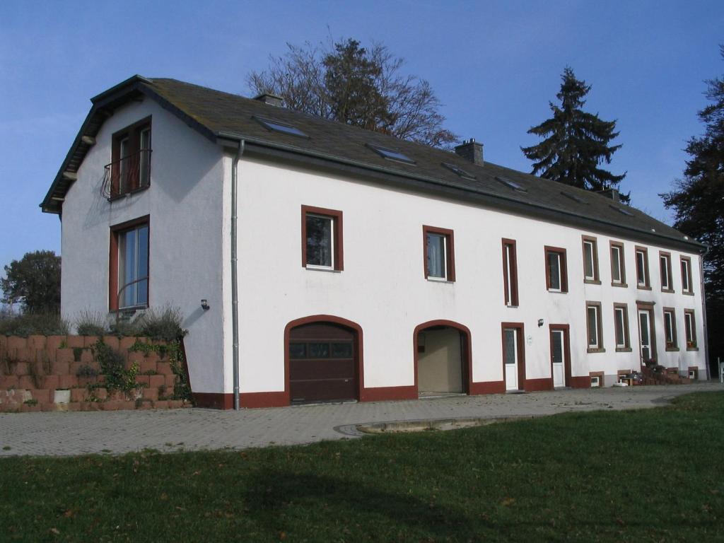 a large white building with a garage at Gîte Klein Rost in Beho