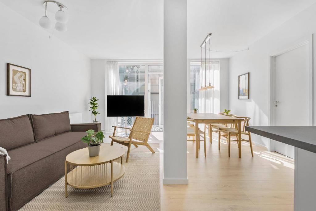 a living room and kitchen with a couch and a table at Amazing 2BR w Balcony in the Heart of Aarhus City in Aarhus