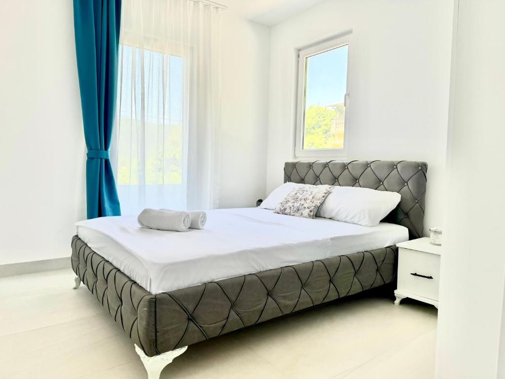 a bed in a bedroom with a large window at Apartmani Asovic in Budva