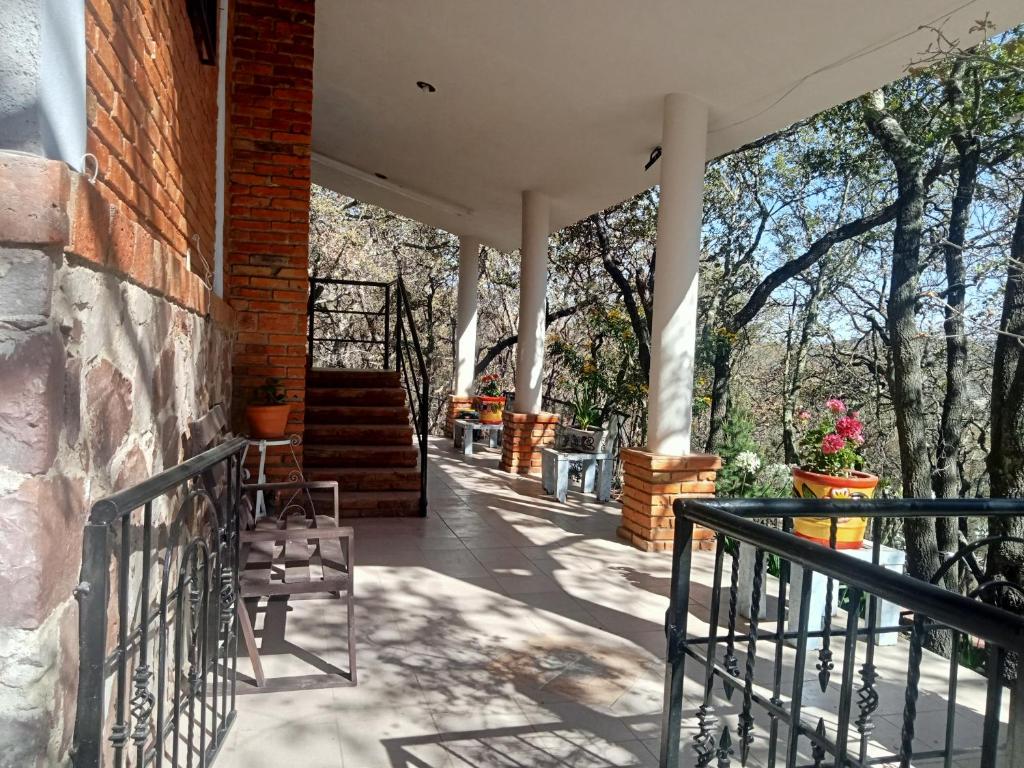 a porch of a house with chairs and stairs at Cabaña Camila in Las Palomas