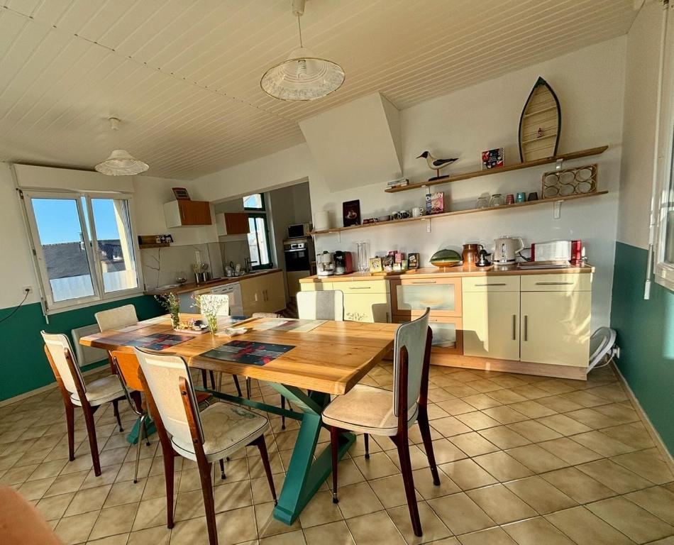 une cuisine avec une table et des chaises en bois dans l'établissement Villa Papyno - Maison 12 personnes - 10mn à pied de la plage - Val André, à Pléneuf-Val-André