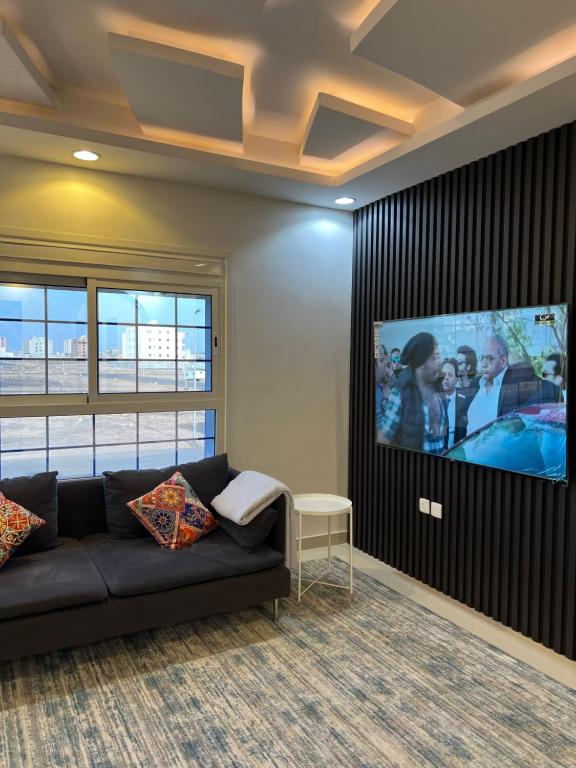 a living room with a couch and a flat screen tv at إطلالة الشرق شقة خاصة 13 كلم عن الحرم East View 13 KM away from Alharam in Al Madinah