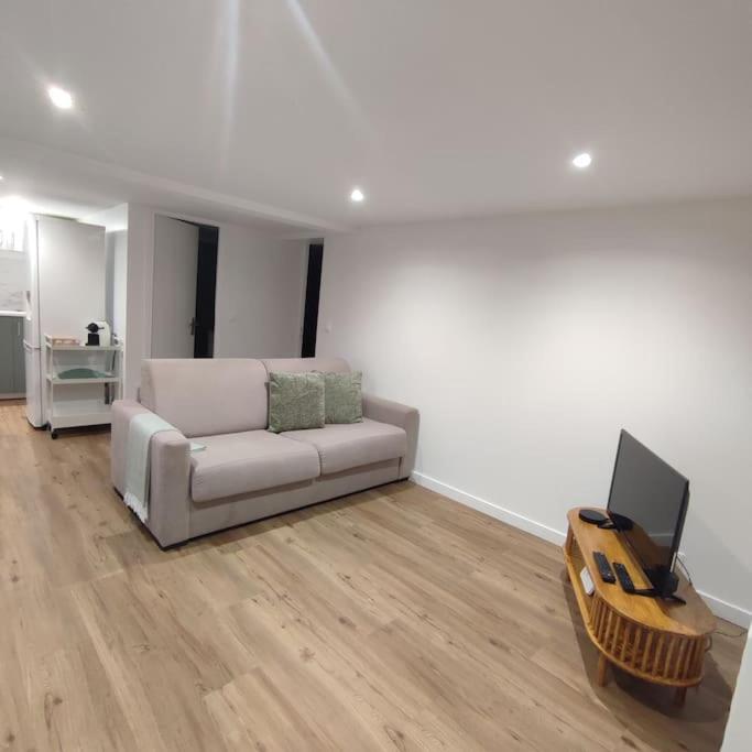 - un salon blanc avec un canapé et une télévision dans l'établissement Studio moderne 4 pers max proche Paris, à Fontenay-lès-Briis