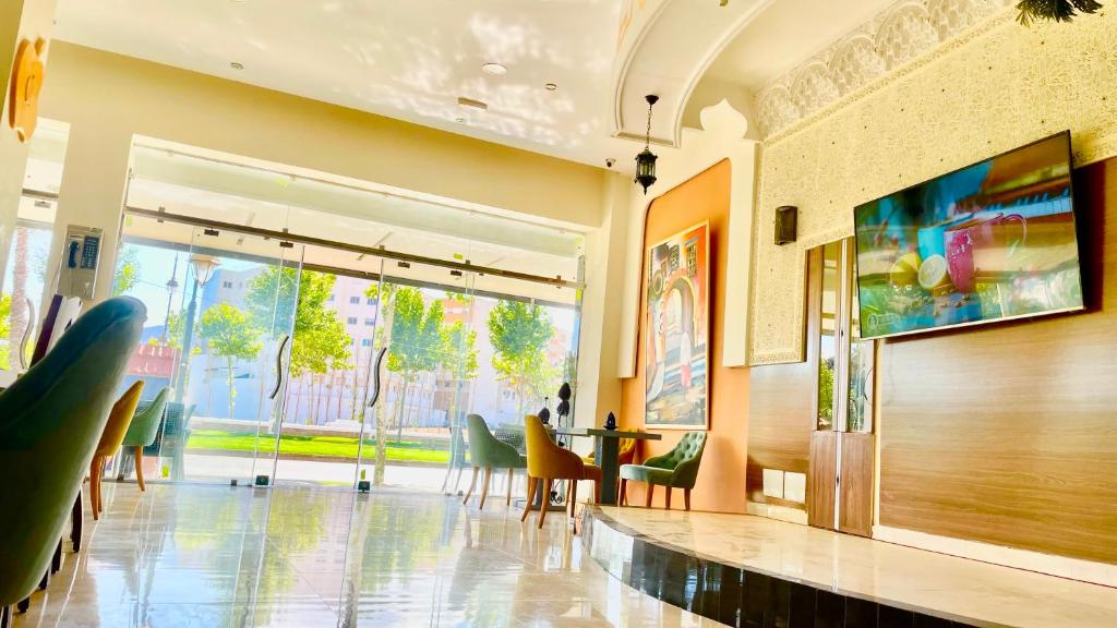 una hall con tavolo, sedie e una grande finestra di Hotel Ryad Tetouan Aero a Tétouan