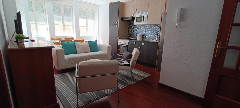 a kitchen and a living room with a couch and a table at Apartamento en Avilés Céntrico & Parking in Avilés