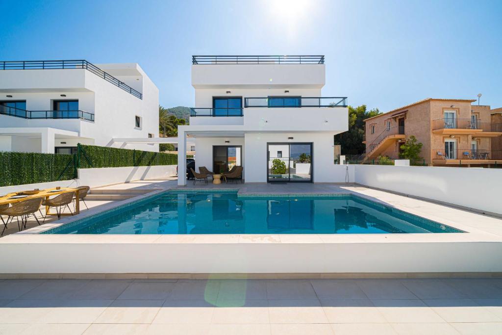 a villa with a swimming pool in front of a house at Casa Albir spaniahome in Albir