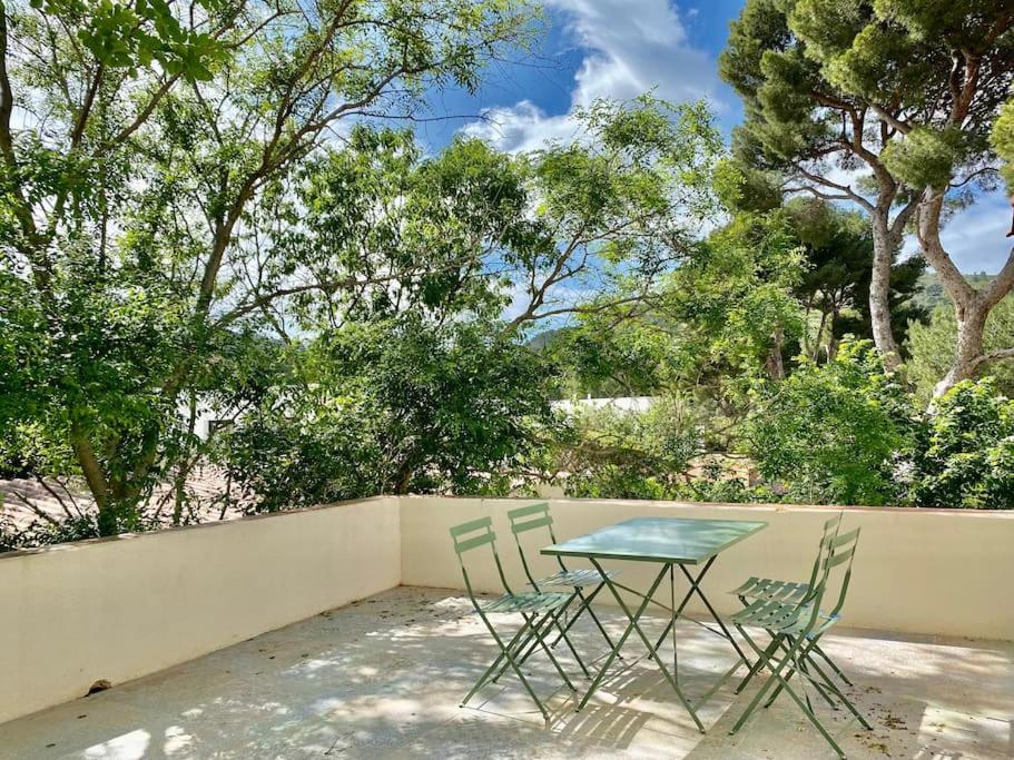 une table et deux chaises assises à côté d'une clôture dans l'établissement Villa Gyptis - Calanques, Calme & Spacieux, à Marseille