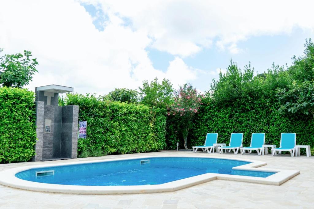 a swimming pool with blue chairs and a group at Istrian Azure in Pula