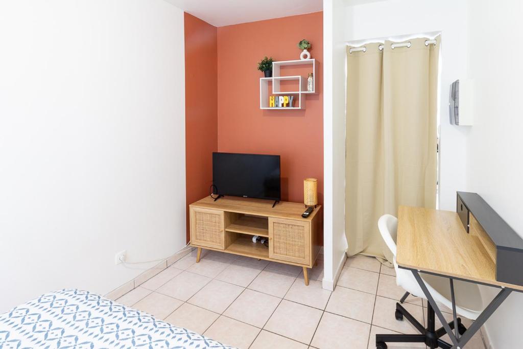 Cette chambre dispose d'une télévision et d'un bureau avec une table. dans l'établissement *Le Gicquel* T1 proche centre, à Brest