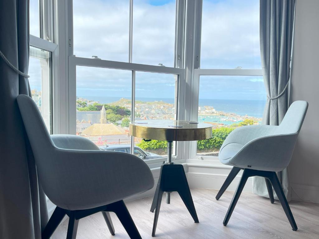 two chairs and a table in front of a window at Henrys in St Ives