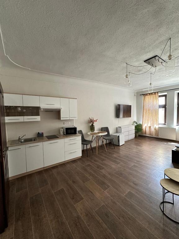 pusta kuchnia i salon ze stołem i krzesłami w obiekcie Kovarik Apartments I w Ołomuńcu
