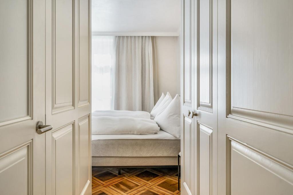 un dormitorio con una cama y una ventana en BLUME Baden Hotel &amp; Restaurant, en Baden