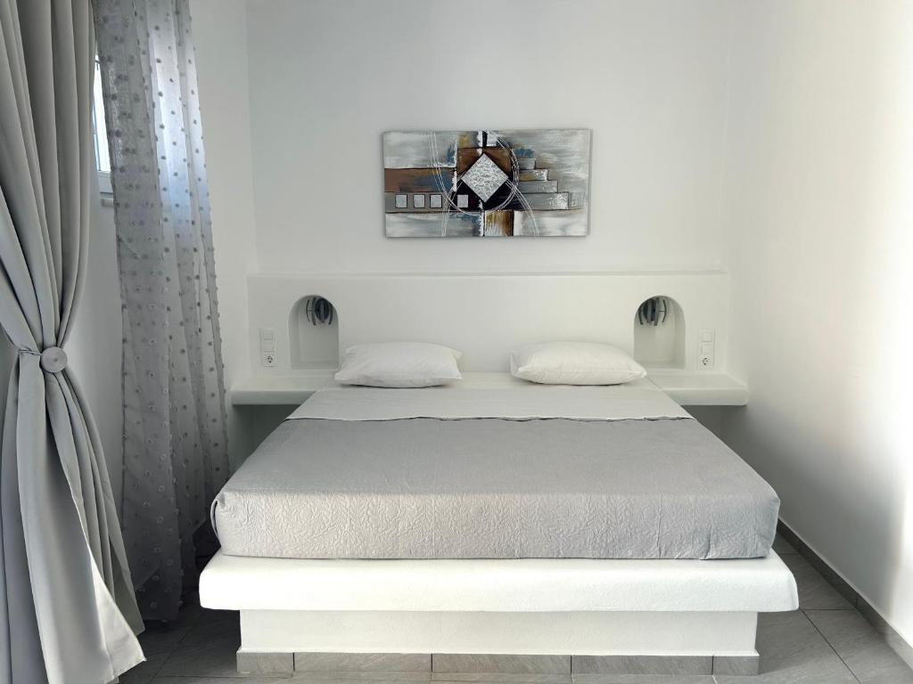 a white bedroom with a bed in a room at Antiparos Diamond in Antiparos Town
