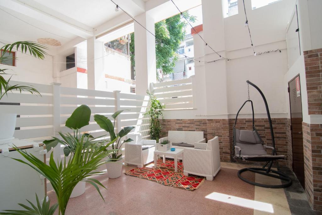 Hotel Il Duca, a room with white furniture and plants in it at Il Duca in Taranto