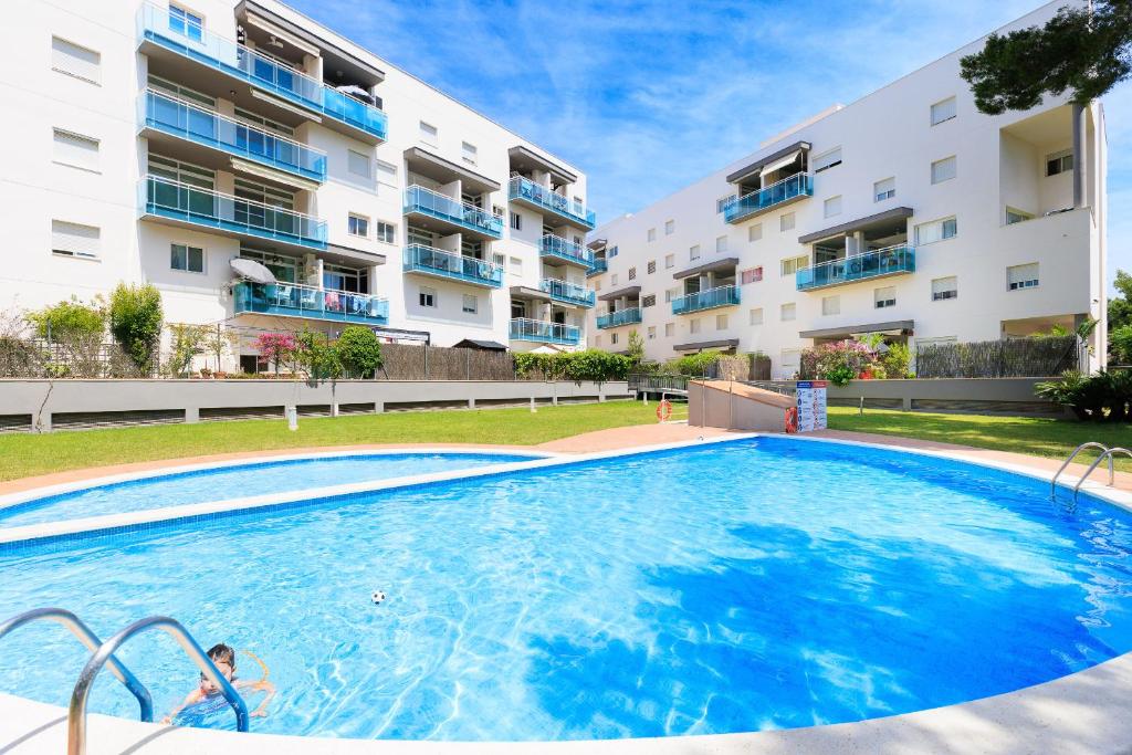 una gran piscina frente a un edificio en UHC GOLDEN PINEDA APARTMENTS, en La Pineda