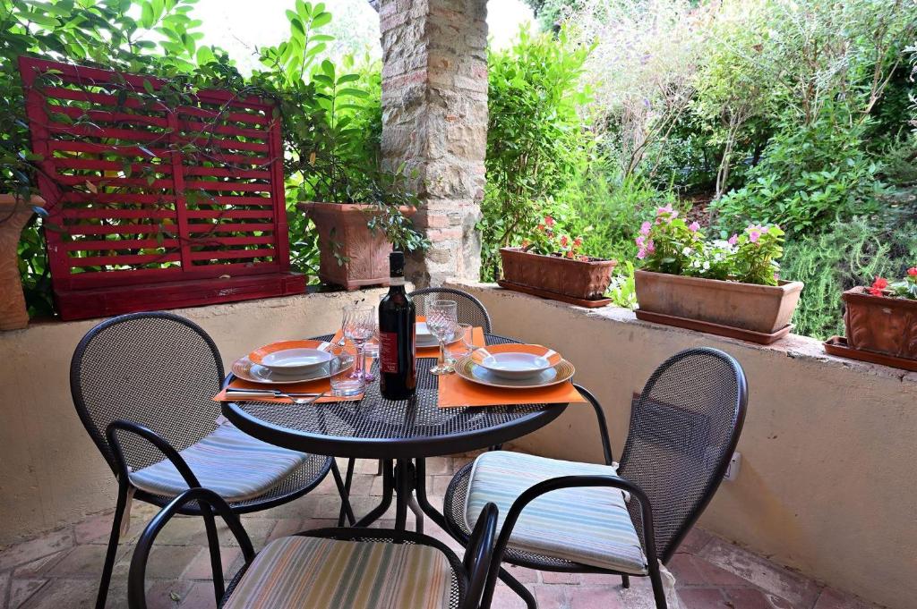 une table et des chaises assises sur une terrasse dans l'établissement Il Portico, à Gaiole in Chianti