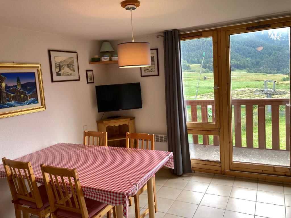 a dining room with a table and a balcony at Duplex cosy à Termignon-Val Cenis, 7 pers, au pied des pistes, balcon, garage, Wi-Fi gratuit - FR-1-508-295 in Termignon