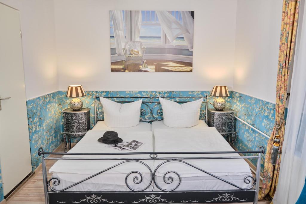 a bedroom with a bed with two lamps on it at Anno 1900 Hotel Babelsberg in Potsdam
