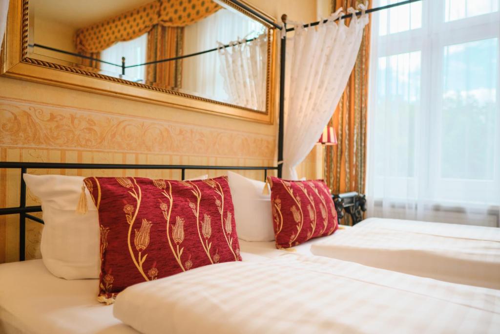 a bedroom with a bed and a mirror on the wall at Anno 1900 Hotel Babelsberg in Potsdam