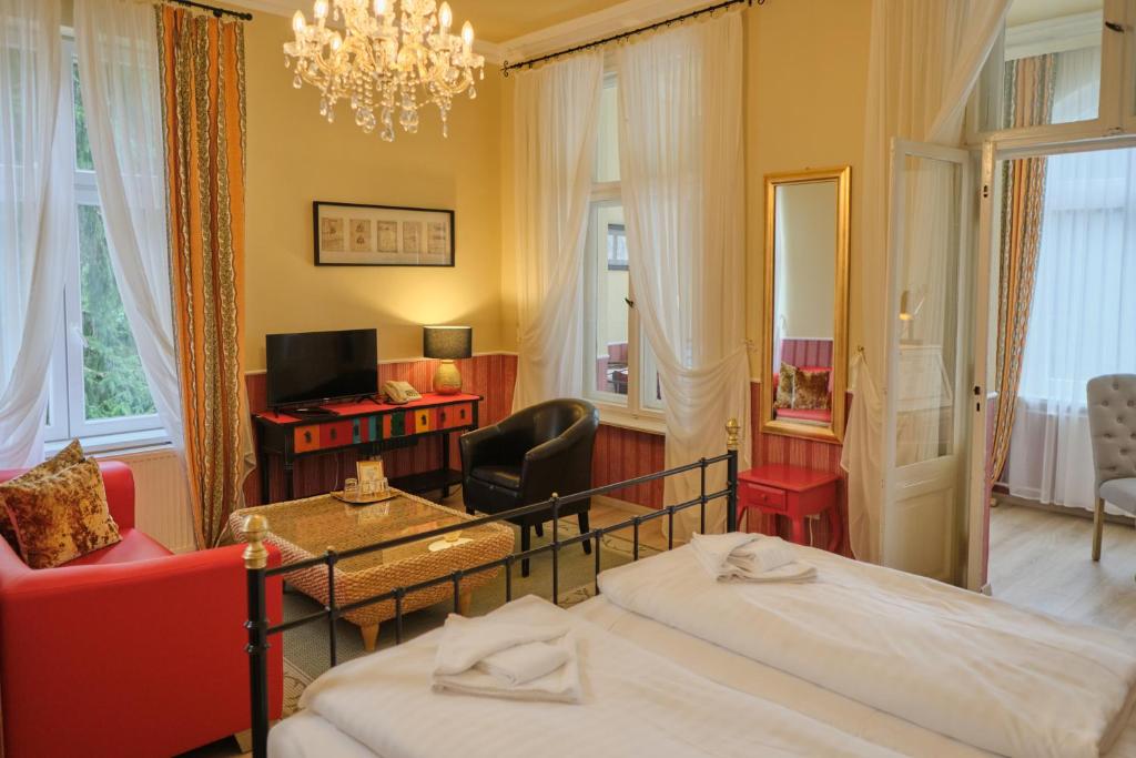 a bedroom with two beds and a chandelier at Anno 1900 Hotel Babelsberg in Potsdam