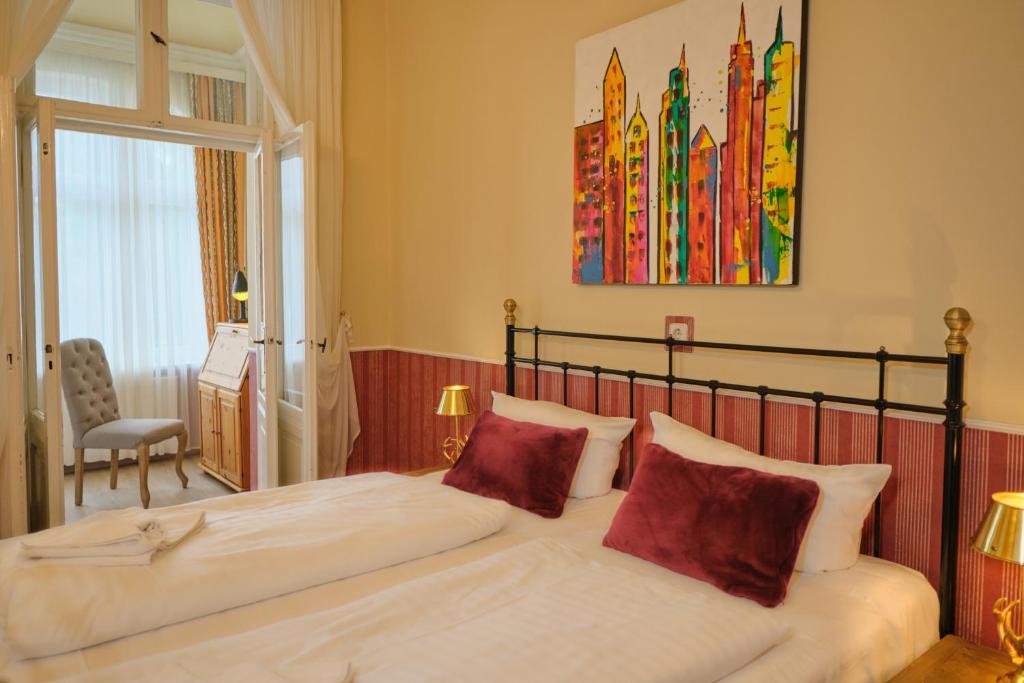 a bedroom with a large bed with red pillows at Anno 1900 Hotel Babelsberg in Potsdam