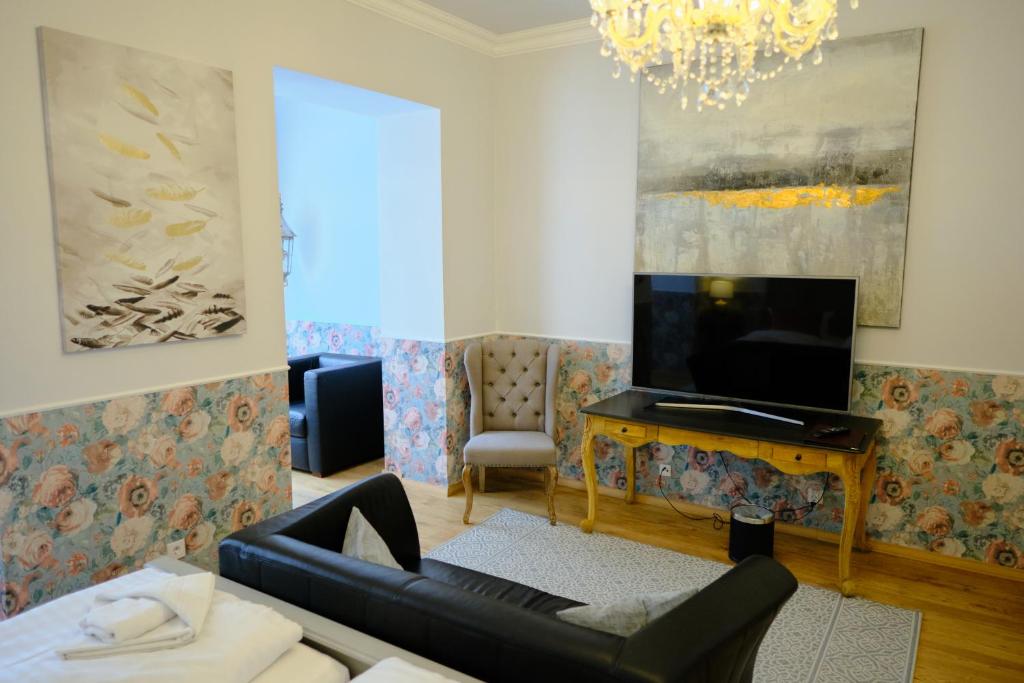 a living room with a couch and a television at Anno 1900 Hotel Babelsberg in Potsdam