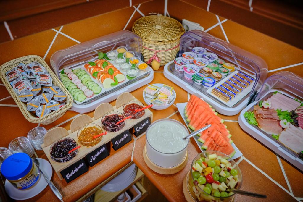 a table topped with trays of food and other foods at Anno 1900 Hotel Babelsberg in Potsdam