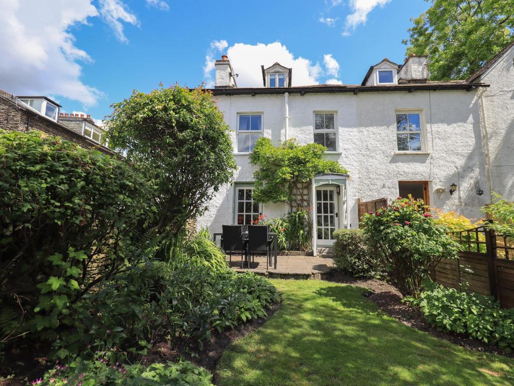 einen Blick auf ein weißes Haus mit einem Hof in der Unterkunft Brook Cottage in Windermere